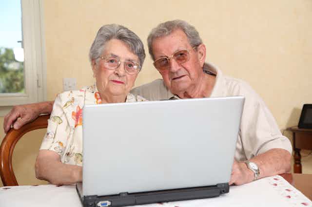 Dos personas mayores ante un ordenador. 