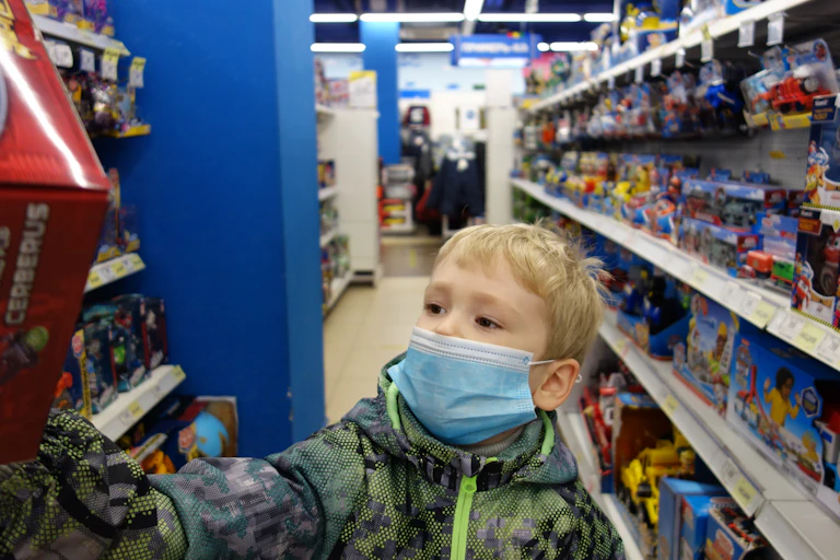 A boy reaches for a toy in a store.
