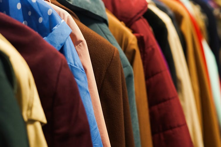Colourful coats and hooded jackets on a rail.