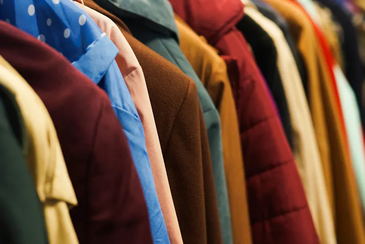 Colourful coats and hooded jackets on a rail.