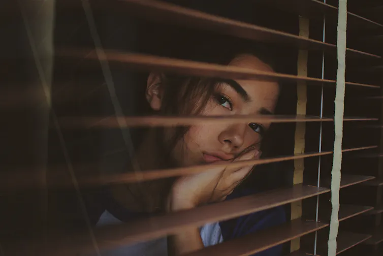 Une femme regarde par la fenêtre