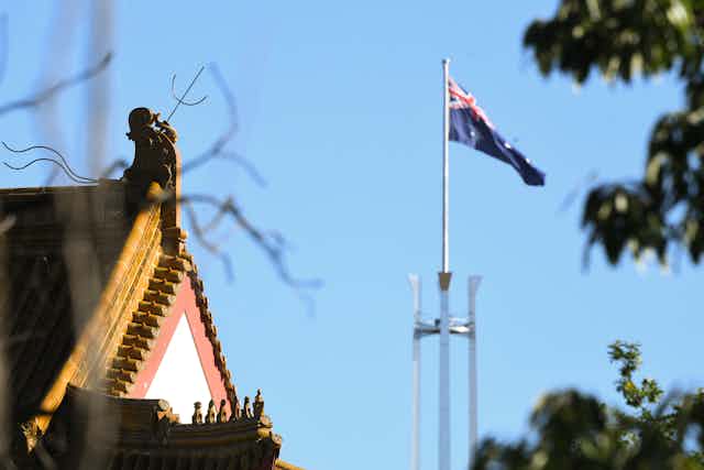 Chinese Embassy roofline next to the Parliament House flag.