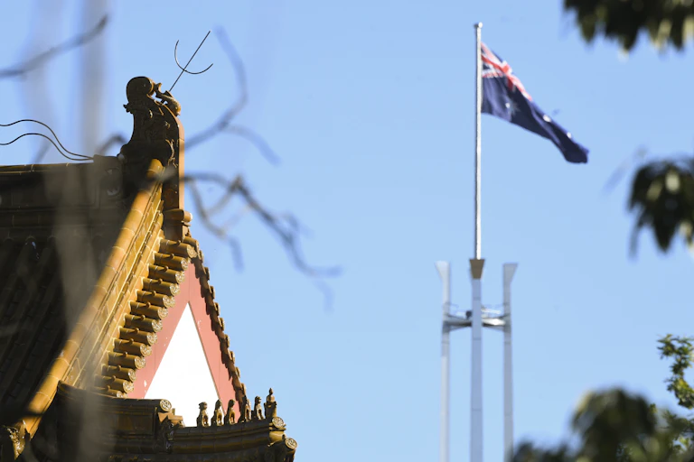 Chinese Embassy roofline next to the Parliament House flag.
