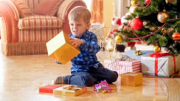 A toddler looking unhappy at gift