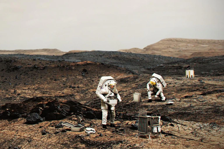 An artist drawing of twopeople in spacesuits walking on Mars.