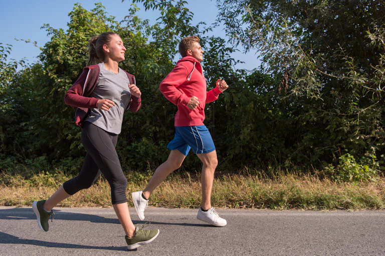 A young girl and boy running outdoors.