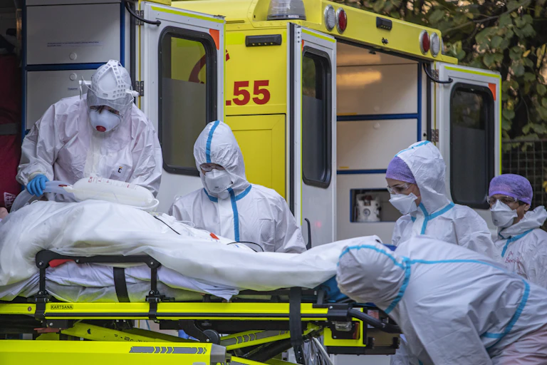 Health workers in the Czech Republic transport a COVID patient from an ambulance into a hospital