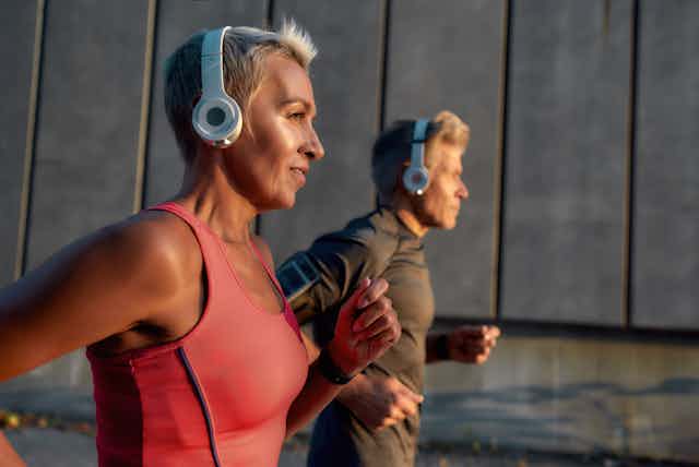 Una pareja con auriculares hace ejercicio al aire libre