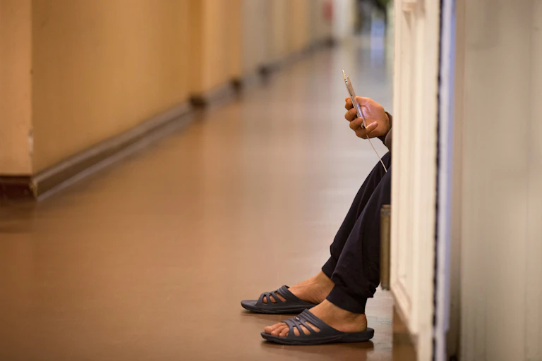 Person holding phone and sitting down