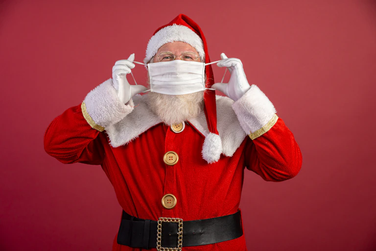 Santa putting a surgical mask on.