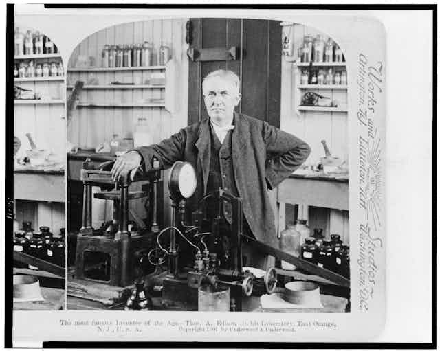 A black-and-white photograph of and older white man in a laboratory circa 1900