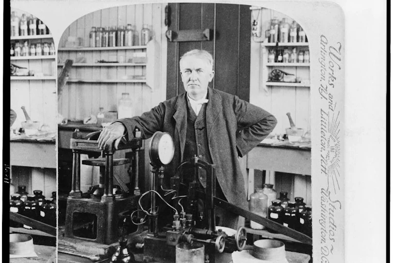 A black-and-white photograph of and older white man in a laboratory circa 1900