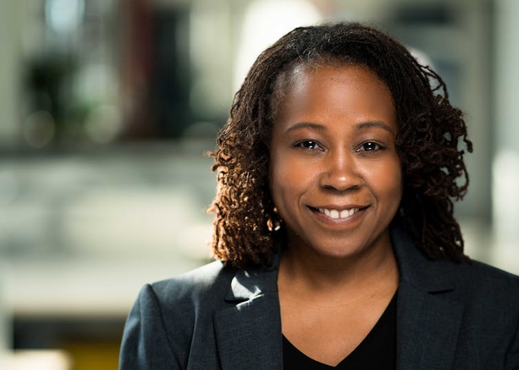 Photograph of a black woman smiling and facing the camera