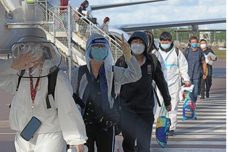 International students disembark from the first flight to land in Darwin