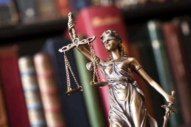 Justice scales in front of a bookshelf