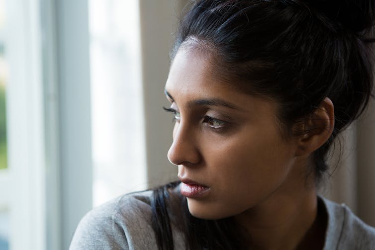 Young woman looking out a window.