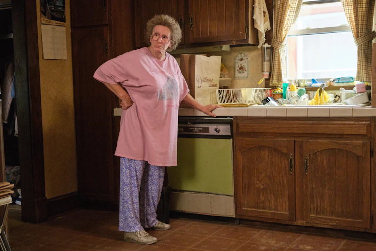 Actress Amy Adams wears a pink oversized t-shirt and leans against a kitchen countertop.