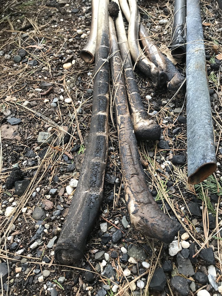 Melted plastic pipes alongside metal pipes.