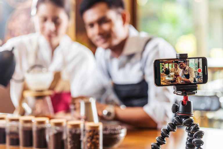 Man and woman record themselves making coffee on a smartphone.