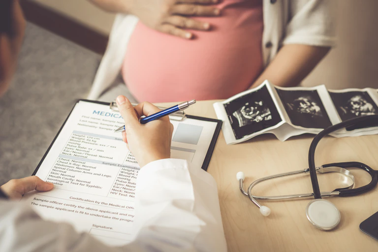 A pregnant woman meets with her doctor.