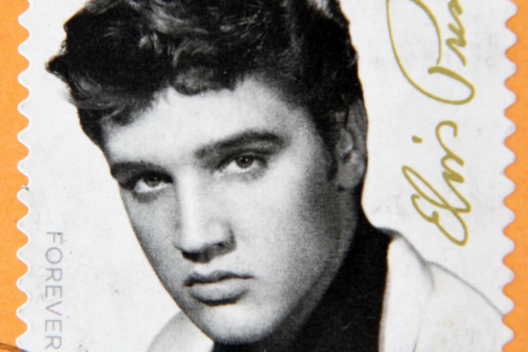 Black and white stamp of Elvis Presley on orange background