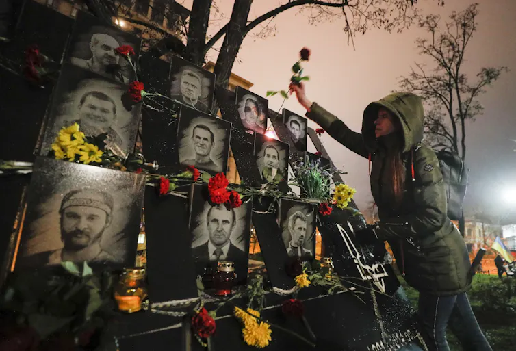 A Ukrainian lays flowers at the memorial for Maidan activists or 'Heroes of the Heavenly Hundred', who were killed on the Maidan during anti-government protests in 2014.