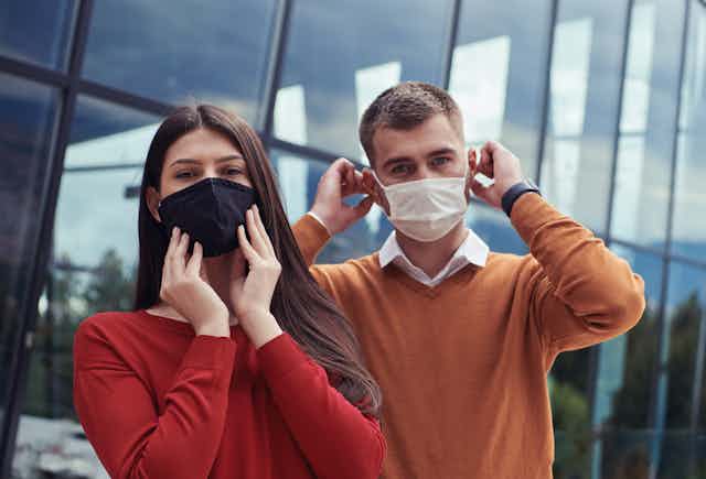 A man and a woman wearing masks