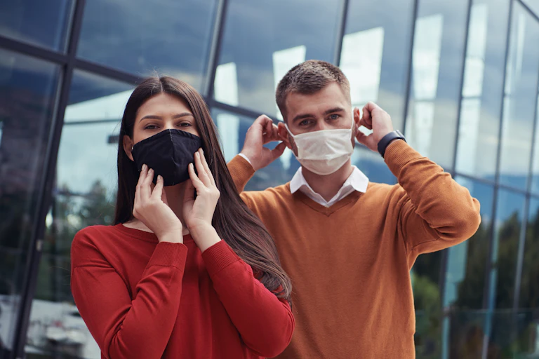 A man and a woman wearing masks
