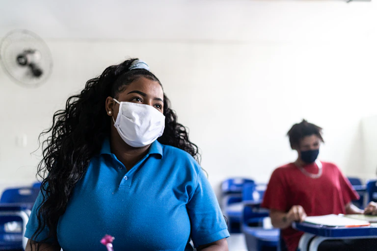 An African American female students pays attention in class.