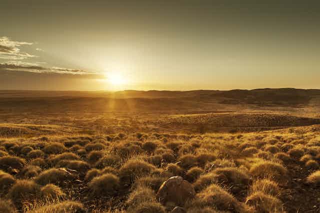 A sunset over an arid landscape in the Australian outback.