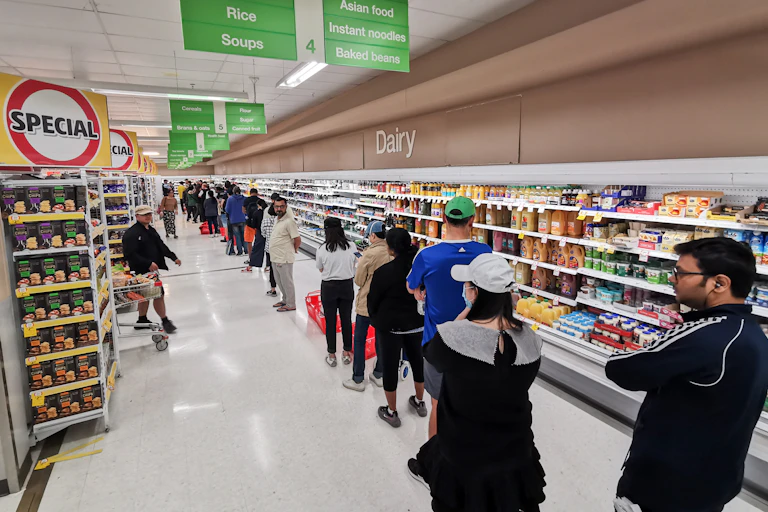 Shoppers lined up in a supermarket aisle