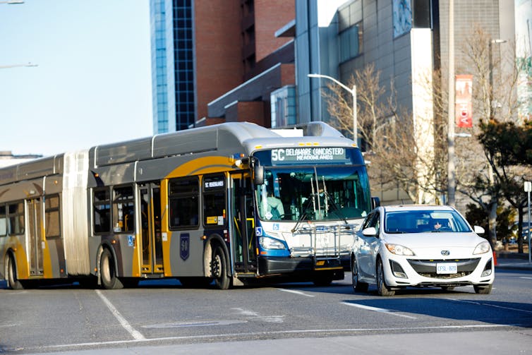 photograph of a car and a bus driving