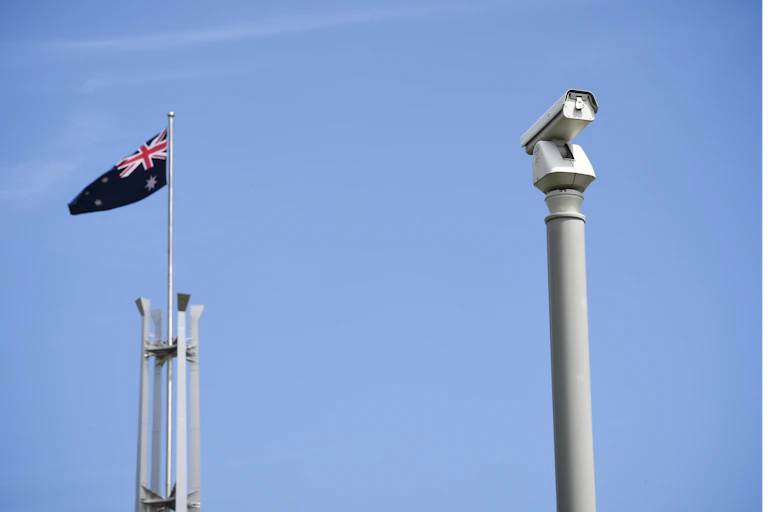 A CCTV camera next to an Australian flag