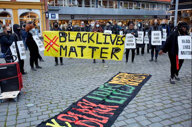 Protesters holding up a sign reading 'black lives matter'.
