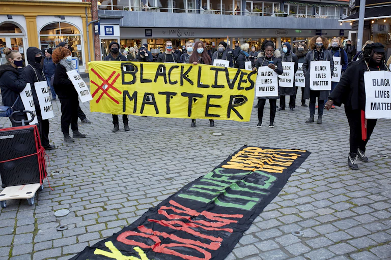 Protesters holding up a sign reading 'black lives matter'.