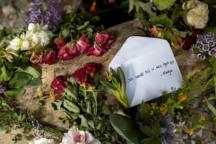 Flowers and an envelope reading 'sleep well until we see each other again' in Danish.