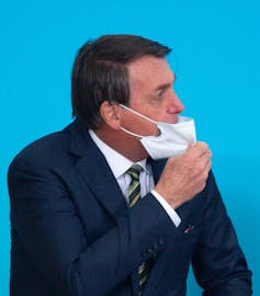 Bolsonaro adjusts his mask