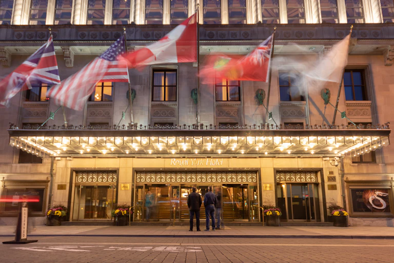The front of a hotel lit up with five flags