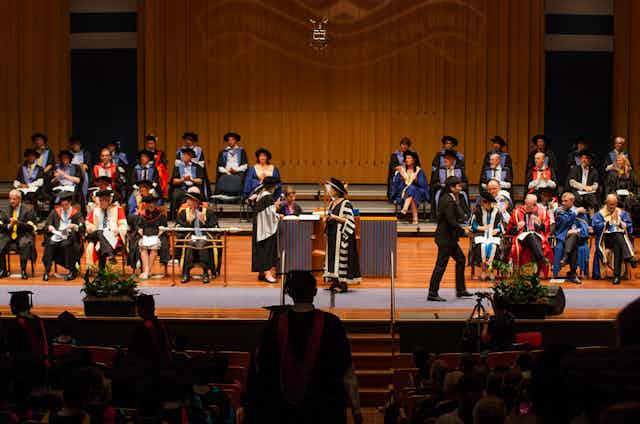 university leaders on stage during graduation ceremony
