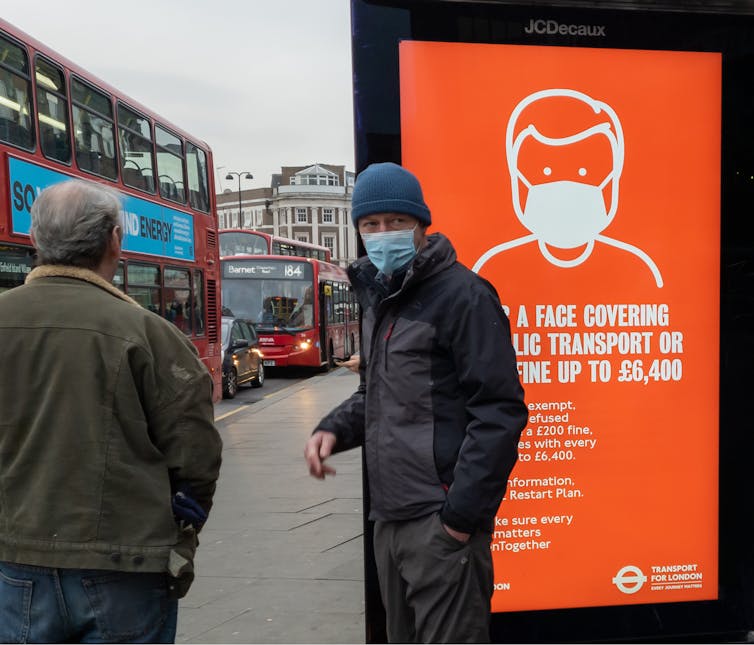 A public health advert in London, stating that not wearing a mask on public transport could lead to a £6,400 fine