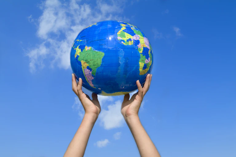 Young girl holding inflatable Earth.