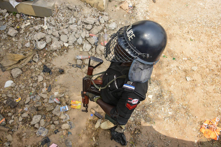 Picture from above of a police officer in a helmet and face shield holding a gun
