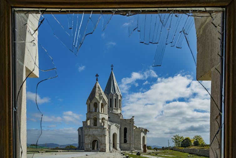 View of a damaged cathedral from a broken glass window