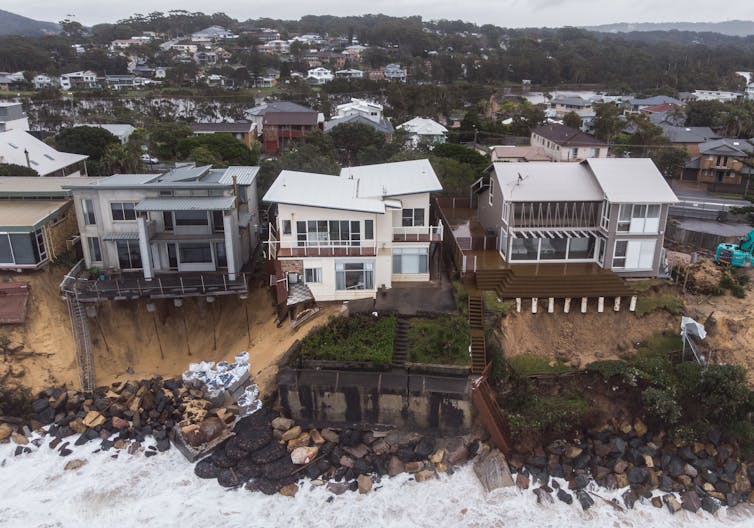 Houses damaged by storms along a beach