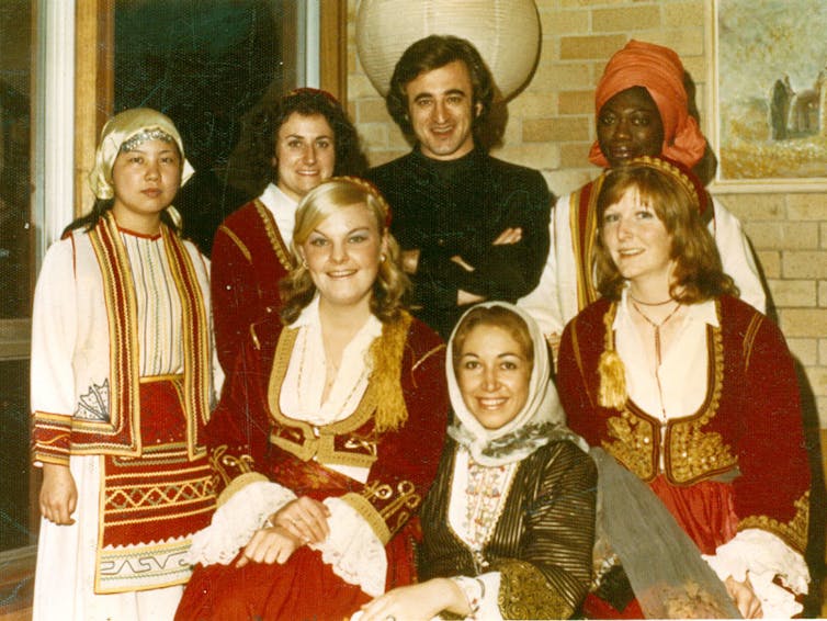 An international group of people dressed in traditional Greek costumes.