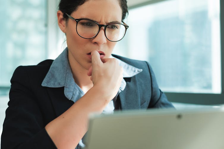 Woman looking stressed, working on a computer