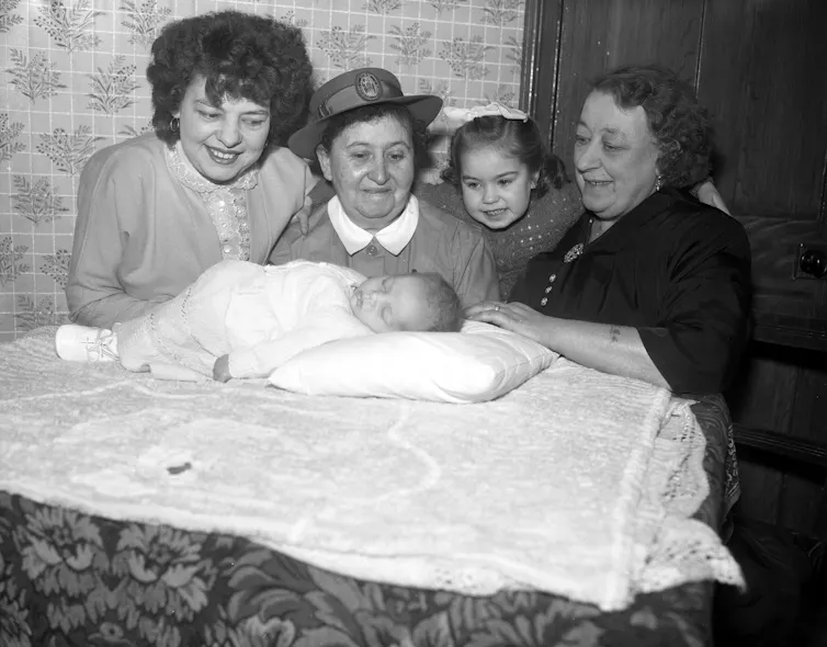 Black and white photo of three women, a girl, and a baby.
