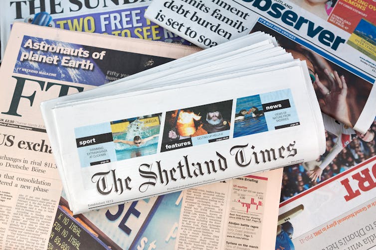 Shetland Times newspaper sits on a pile of UK national papers.