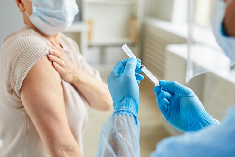 A nurse administering a vaccine to a patient