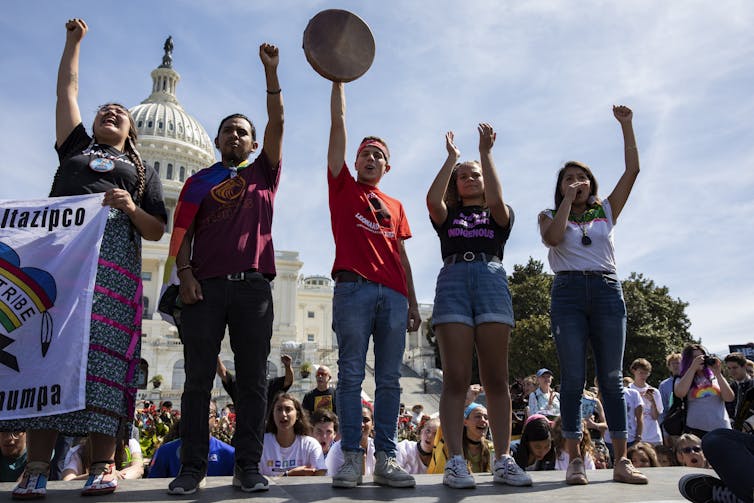 Five young Native Americans in front of the US Capitol building.